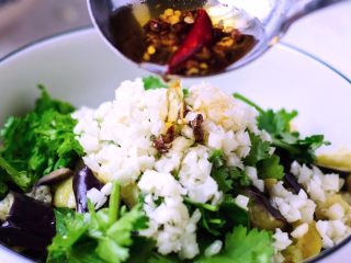 7、凉拌鱼香茄子,把香辣油趁热浇在蒜粒上，激出香味。