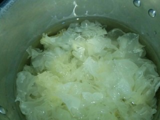 2、银耳菠萝枸杞糖水,把银耳上面的头切掉，然后撕小片。锅里倒入水，把备好的银耳放入锅里，中火熬煮30分钟左右