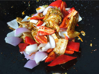 11、辣白菜生爆回锅肉,将甜椒洋葱放入锅里，炒至蔬菜变色变软。