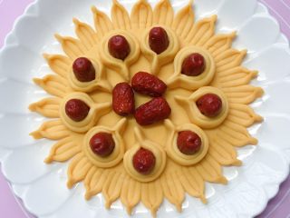 11、富贵花开枣花馍,依法制作9个相同大小的花瓣，然后摆放在之前做好的枣花馍底部上，中间部位再放上三颗红枣填满。