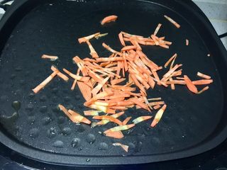 9、黄金黑米卷,电饼铛留底油，先放入胡萝卜丝翻炒。