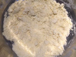 2、暖心南瓜派,黄油混合糖粉,低筋面粉成絮状,加入蛋黄混合均匀,成团后放入冰箱冷藏30分钟,或冷冻15分钟,备用