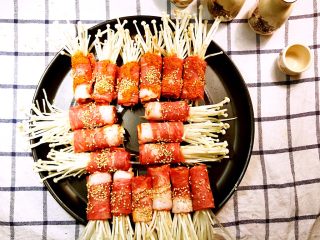 9、经光波烘焙的金针菇培根卷,调整金针菇培根卷在烤盘内的烘焙位置后，再放入光波炉中。