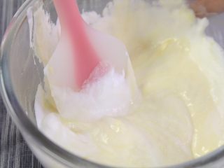 3、百香果慕斯蛋糕,蛋白分三次与蛋黄糊翻拌混合均匀