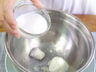 7、百香果慕斯蛋糕,打蛋盆隔热水。倒入奶酪分多次加入牛奶和百香果汁搅拌至顺滑。