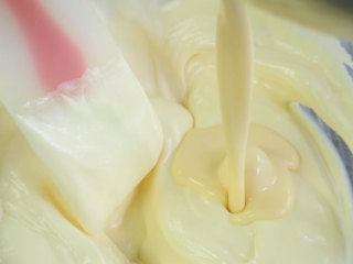 10、百香果慕斯蛋糕,将混合好的百香果糊分三次与打发的淡奶油翻拌均匀。