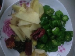 2、家庭版孜然烤鱼,准备材料。，姜切片，大蒜剥皮，青椒切段，加花椒放盘子备用，另外同时准备好洋葱切丝，泡椒酸豆角，孜然粉，细红辣椒面，以及豆瓣酱。