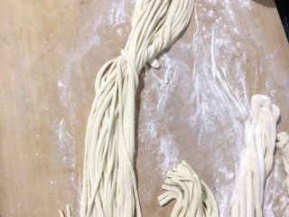 5、扯面,把切开的面条手抓两段，慢慢的拉面，就会变成拉面，然后在把两段的切下去
