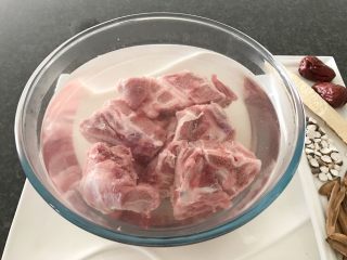 2、肇实灵芝片煲肉骨汤,首先我们将肉骨浸泡在清水里10-15分钟（去血丝）