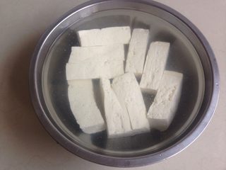 1、酸甜豆腐条,买回来的豆腐，放入有盐的水里浸泡。然后将豆腐切成三份。
