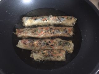 23、腐皮卷,锅烧热倒入适量油，待油温烧至七成热时放入腐皮卷，用大火快速炸熟