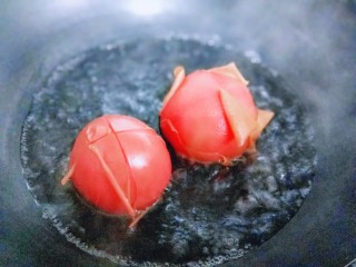 3、番茄炒蛋盖浇饭,锅中加入水，大火烧开，放入番茄，将番茄去皮，煮至番茄表皮裂开即可捞出。