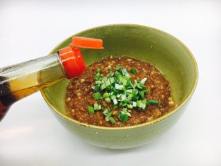 6、#咸味#  地方特色海鲜汤小云吞 ,放入葱花，在葱花上倒入约1小勺左右的香油，用香油把葱花搅拌一下，裹住葱花，再把葱花搅拌至肉馅中去。