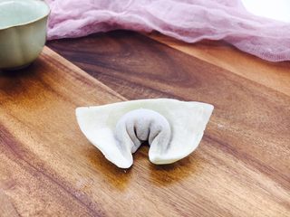 12、#咸味#  地方特色海鲜汤小云吞 ,如图，把两个角弯过来，然后捏在一起。