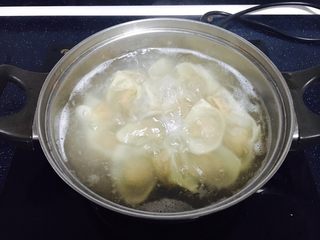 15、#咸味#  地方特色海鲜汤小云吞 ,放入小云吞，用小勺轻轻推动小云吞的底部，避免粘锅。