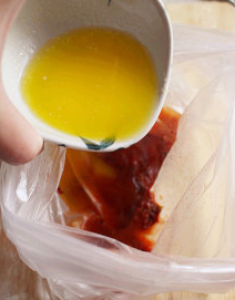 1、水牛城辣鸡翅,准备一塑料袋,将墨西哥辣椒酱+黃油+白醋+辣椒粉+红椒粉+白胡椒粉,全部入袋中混合均匀