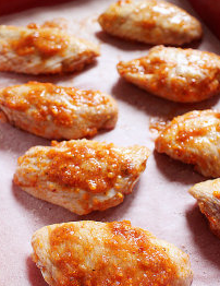 8、水牛城辣鸡翅,鸡翅放入铺有烤盘纸的烤盘上,腌料可铺在鸡翅表面