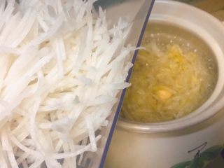 8、羊肉丸子萝卜酸菜粉丝砂锅,时间差不多了，现在可以把萝卜丝放进去了。