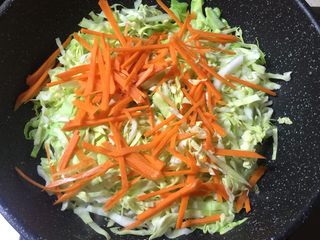 4、玉米肠蛋炒饭,锅里留油，放入包菜，红萝卜炒软。