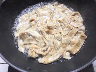 12、烫鸡蛋皮,清水烧开,蛋皮丝入沸水煮1分钟左右,倒入炒好的白菜,加一点点盐翻煮半分钟