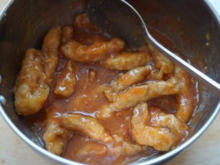 15、了不起的小番茄+糖醋里脊肉,把复炸好的肉沥去油份后放入糖醋酱汁里搅拌均匀