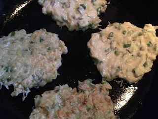 4、槐花饼,热锅淋油，取适量面糊放入锅中，手沾上一点清水，将面糊摊均匀