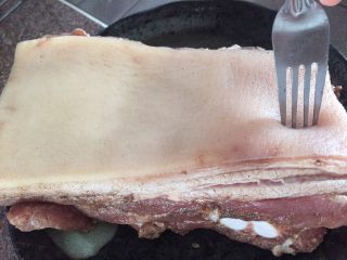 4、粤式脆皮烧肉,煮好肉捞出，用叉子在皮的部分插孔，一定要插的密密麻麻，整片皮没有插满孔的话会影响脆皮的烧制。