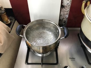 3、家庭煲仔饭,锅中倒入清水煮沸。