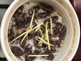 9、家庭煲仔饭,将腊肠平铺在大米上，撒上少许姜丝。