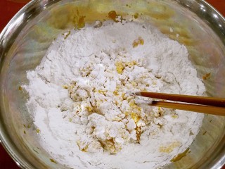 4、红糖南瓜饼,分次分量倒入糯米粉，搅拌一下。