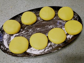 9、红糖南瓜饼,做好的饼胚铺放在撒了糯米粉的盘子或案板上备用。