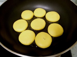 10、红糖南瓜饼,煎锅里倒入食油，小火加热1分钟后，逐个摆放入饼胚，小火慢煎。