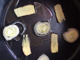 8、盐焗猪肝,电饭锅里铺上葱片姜片，倒入玉米油。