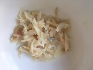 5、油菜鳕鱼蛋黄粥,将鳕鱼小心翼翼地用手先撕开。