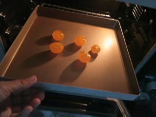 3、咸蛋黄焗南瓜,我用的是自己腌的咸鸭蛋。取蛋黄，表面喷上白酒入烤箱180度烤5分钟。