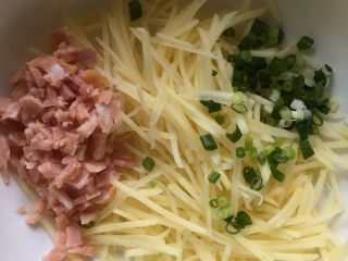 2、葱香培根土豆饼,培根切碎，葱花切沫，土豆丝捞出沥干水分混合。