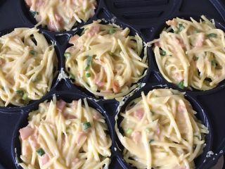 7、葱香培根土豆饼,放入土豆饼糊，底部凝固后翻面再煎。