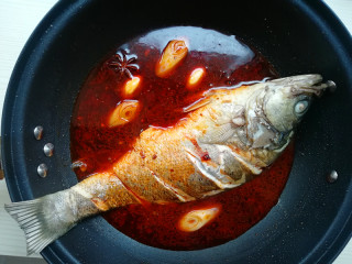 6、【豉香红烧鱼】,淋入料酒,再加入适量热水,老干妈豆豉酱,红烧酱油,白糖、米醋,大火烧开,转小火烧制入味,期间,将鱼翻一次面