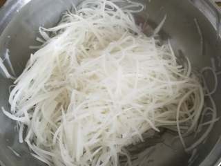 11、萝卜糕,锅内放入萝卜丝，盐，鸡精，盐，开最小火，可以用手翻拌压榨萝卜丝，加速杀水过程