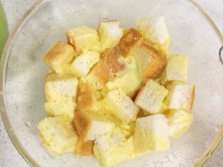 9、宝宝辅食12M➕：南瓜虾仁芝士吐司布丁,将蛋奶液缓缓倒入装有吐司的碗里，轻轻搅拌均匀，让吐司完全吸收蛋液