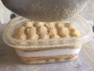 25、家庭版豆乳盒子,再铺一层蛋糕坯,挤上卡士达酱,这次是最后一层,所以卡士达酱挤成圆形。最后再筛入黄豆粉